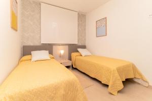 deux lits dans une chambre avec des draps jaunes dans l'établissement Espanatour FLAMENCA VILLAGE 4, à Orihuela Costa 28 autres photos