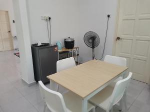 a table and chairs in a room with a refrigerator at Homestay Pasir Tumboh Kota Bharu in Kota Bharu