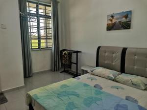 a bedroom with a bed and a window at Homestay Pasir Tumboh Kota Bharu in Kota Bharu