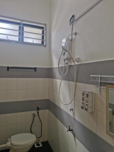 a bathroom with a shower and a toilet at Homestay Pasir Tumboh Kota Bharu in Kota Bharu
