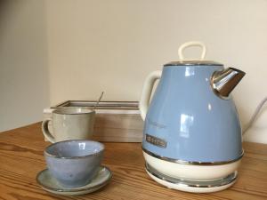 a blue tea kettle and two cups on a table at 't Greefsch Geluck in Kalmthout