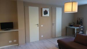 a living room with a door and a television at Appartamento seminterrato Villa Sveva Franciacorta in Ome