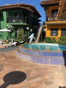 a man standing in front of a swimming pool at Costa Marlin Hotel in Guriri