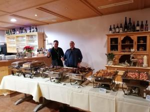 deux hommes debout devant une table de nourriture dans l'établissement Hotel Fischer am See, à Füssen