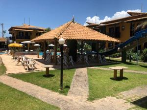 un complexe avec une aire de jeux dotée de tables et de parasols dans l'établissement Costa Marlin Hotel, à Guriri
