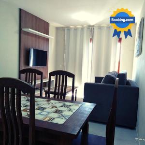 ピパにあるCondomínio Brisas do Amor - 2 Quartos em Pipa Apto106のテーブルと青いソファのあるリビングルーム