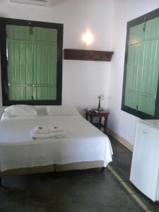 ein Schlafzimmer mit einem Bett mit zwei Handtüchern darauf in der Unterkunft Pousada do Ipe in Goiás