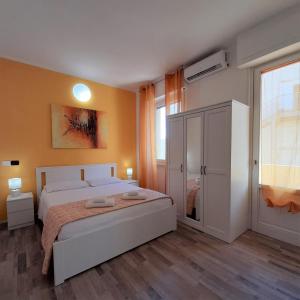 um quarto com uma grande cama branca e uma janela em Iris Rooms em Cagliari