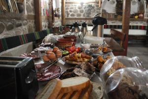 une table recouverte de assiettes de nourriture et de pain dans l'établissement Старата Тонина къща, à Dobrinichte