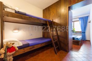 a bedroom with two bunk beds and a ladder at Resort Palace Sestriere 1 e 2 in Sestriere