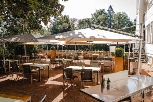 an outdoor restaurant with tables and umbrellas at Maiers Johanniterbad Ringhotel Rottweil in Rottweil