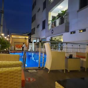 a hotel patio with chairs and a swimming pool at Ziroc Residence Lekki Phase 1 in Lekki