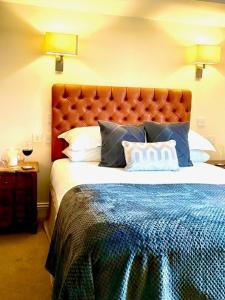 a bedroom with a large bed with a blue blanket at Oak Tree Inn in Brafferton