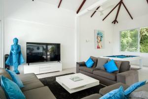a living room with a couch and a tv at Villa SUAY - 2 swimming pool and SEA VIEW by VILLA FOR YOU in Koh Samui