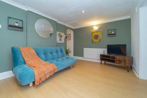 a living room with a blue couch and a television at NEXT TO BRIGHTON SEAFRONT I TWO BED ROOM FLAT WITH OUTSIDE SPACE in Brighton & Hove