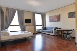 een slaapkamer met een bed, een bank en een tafel bij Duomo Luxury Apartment VII in Milaan