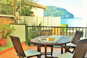 una mesa y sillas en un balcón con vistas al océano en Port de Sóller Promenade Apartment. en Port de Soller