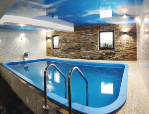 eine große blaue Badewanne mit zwei Wasserhähnen in der Unterkunft Vila Seva in Vatra Dornei