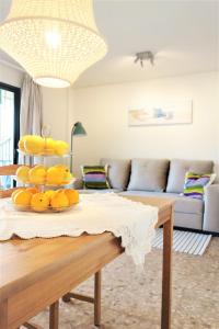 una sala de estar con una mesa con naranjas. en Port de Sóller Promenade Apartment., en Puerto de Sóller