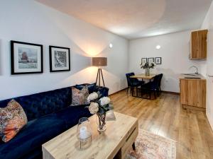 a living room with a blue couch and a table at Guesthouse Check In in Stolac