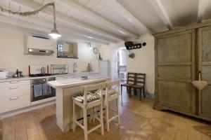 a kitchen with white cabinets and a table and chairs at Residenza Stoechas in Albenga +25 photos