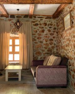 a living room with a couch and a stone wall at Apartment Old House in Podgorica