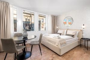 een slaapkamer met een wit bed en een tafel en stoelen bij Apartments Penkala 2 in Rijeka