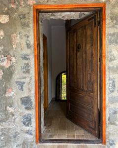 una puerta de madera abierta en una pared de piedra en Apartment Old House en Podgorica