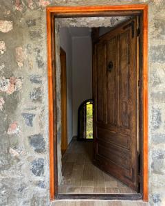 an open wooden door in a stone wall at Apartment Old House in Podgorica