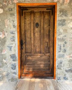 una puerta de madera marrón en una pared de piedra en Apartment Old House en Podgorica
