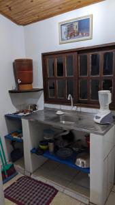 a kitchen with a sink and a counter top at Cecilia & Pretinho's House in Vale do Capao