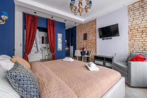 a bedroom with a bed and a couch and a chair at Romantika Smolny appartment in Saint Petersburg