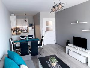 ein Wohnzimmer mit einem Esstisch und einer Küche in der Unterkunft BBR26- Sea View First Line Apartment Sarafovo in Burgas City