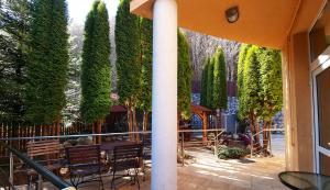 une terrasse avec des arbres, des bancs et une fontaine dans l'établissement Marble Villa: Luxury estate - central but intimate, à Sinaia