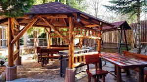 um gazebo de madeira com uma mesa de piquenique e bancos em Marble Villa: Luxury estate - central but intimate em Sinaia