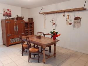 een eetkamer met een houten tafel en stoelen bij Eclosion de lumière in Montmirail