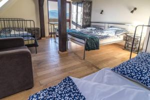pokój z 3 łóżkami w pokoju z drewnianą podłogą w obiekcie WYSPA KONI - urocze gospodarstwo agroturystyczne w mieście Ostroszowice