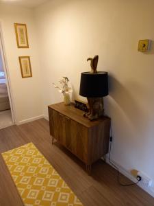een woonkamer met een tafel met een lamp erop bij Moore Apartment in Bourton on the Water