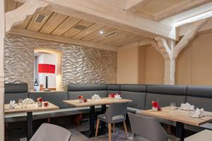 ein Esszimmer mit Tischen und Stühlen und einer Steinmauer in der Unterkunft Hotel Fuchsen in Kirchheim unter Teck