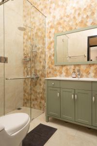 普禾加多的住宿－Hening Pool Villa，带淋浴、卫生间和盥洗盆的浴室