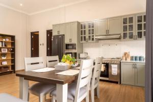 普禾加多的住宿－Hening Pool Villa，厨房配有木桌和白色橱柜。