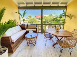 a living room with a couch and a table at Ti Bo Paradise, 150 m from Orient Bay Beach in Orient Bay