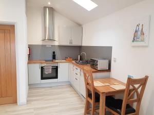 a small kitchen with a table and a microwave at Wyvern Apartment in Yeovil