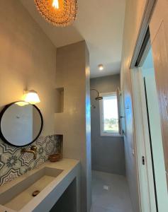 La salle de bains est pourvue d'un lavabo et d'un miroir. dans l'établissement Villa Casa Bianca di Porto Selvaggio, à Santa Caterina