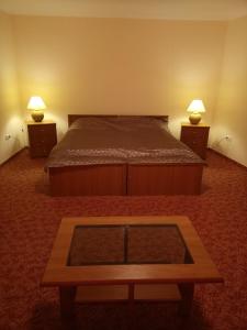 a bedroom with a bed and two night stands with lamps at Budányi Vendégház in Tállya