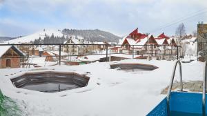 um telhado coberto de neve de uma cidade com edifícios em SPA Resort HeRICH em Bukovel