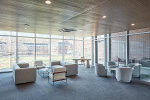 a waiting room with chairs and tables and windows at Harmony Lofts on Jackson 2 in Hoboken