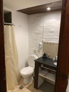 a bathroom with a white toilet and a sink at Kimbara Aparts in Mar de las Pampas