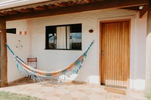 a hammock on the side of a house at Pousada Cafune in Socorro