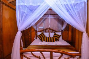 una camera con letto a baldacchino e 2 cuscini di Sigiriya Rock Gate Tree House a Sigiriya